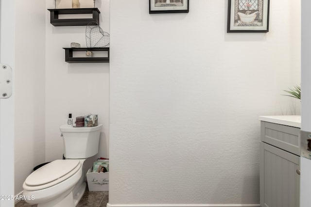 bathroom with tile patterned flooring, vanity, and toilet