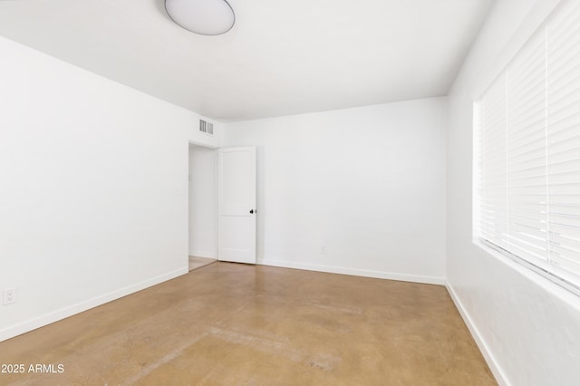 unfurnished room with concrete flooring