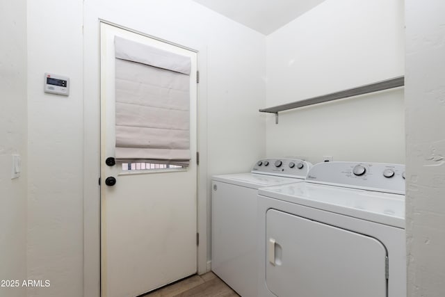 laundry room featuring washing machine and dryer and light wood-type flooring