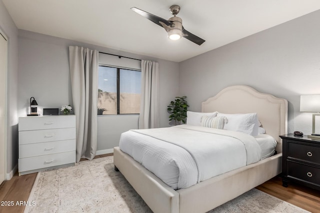 bedroom featuring a ceiling fan, baseboards, and wood finished floors