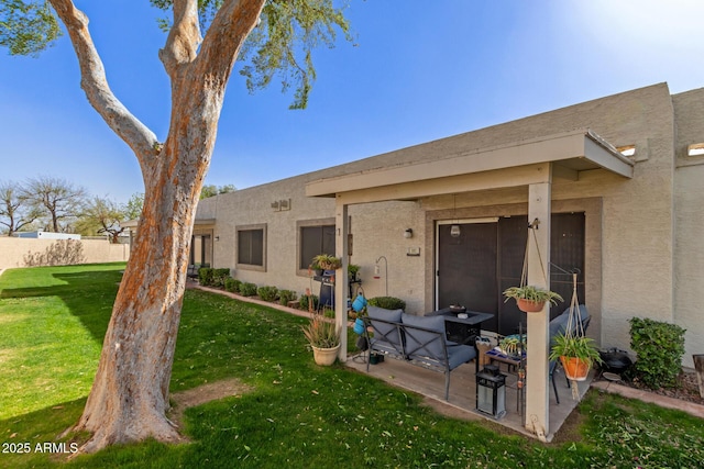 exterior space featuring a patio area, a yard, and stucco siding