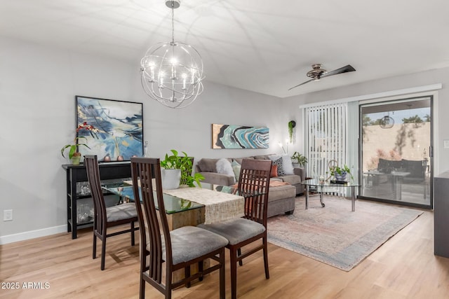 dining area with baseboards, ceiling fan with notable chandelier, and light wood-style floors