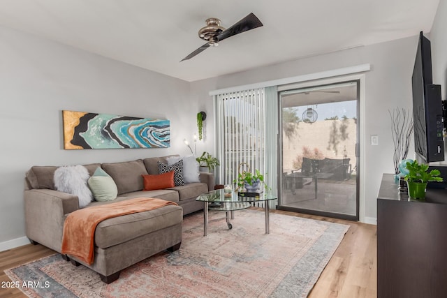 living room featuring ceiling fan, baseboards, and light wood-style floors