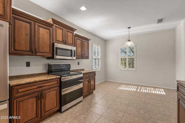 kitchen featuring stainless steel appliances, decorative light fixtures, and light tile patterned floors