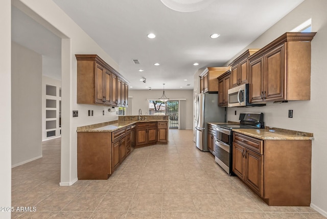 kitchen with stainless steel appliances, light stone countertops, hanging light fixtures, and kitchen peninsula