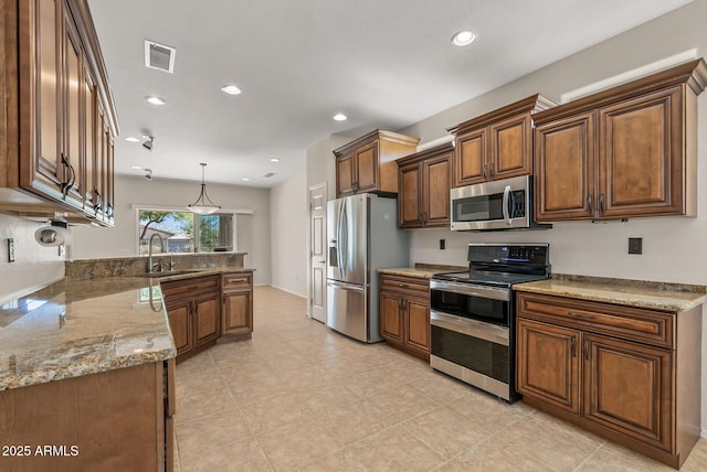 kitchen with stainless steel appliances, light stone countertops, sink, and hanging light fixtures