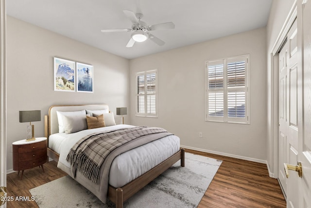 bedroom featuring ceiling fan, dark hardwood / wood-style flooring, and a closet