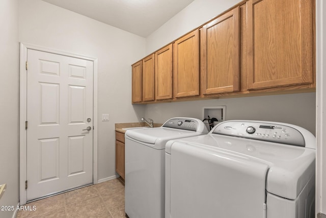 washroom with cabinets, sink, light tile patterned floors, and washer and clothes dryer