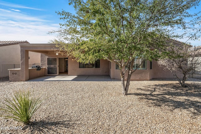 rear view of property featuring exterior kitchen and a patio