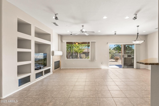 unfurnished living room with light tile patterned flooring, plenty of natural light, a fireplace, and built in features