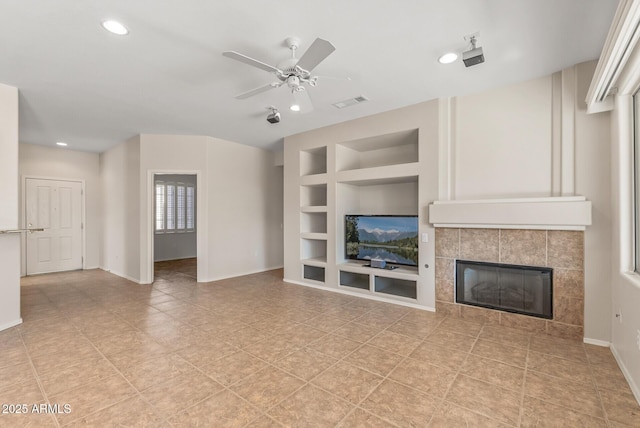 unfurnished living room featuring built in features, a tile fireplace, and ceiling fan