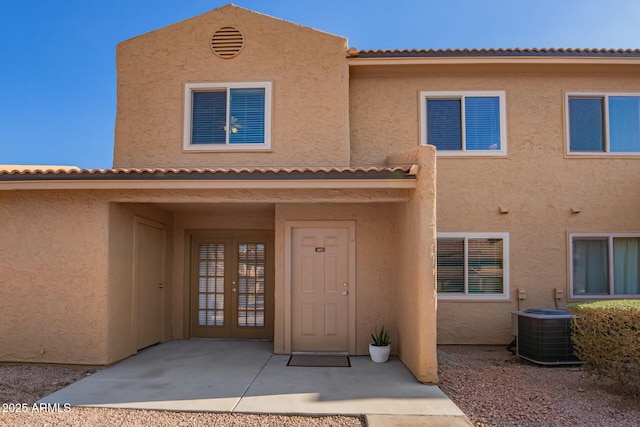 exterior space with cooling unit and stucco siding