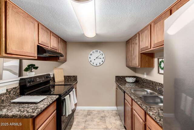 kitchen with baseboards, under cabinet range hood, appliances with stainless steel finishes, a textured ceiling, and a sink