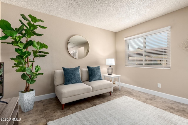 living area with baseboards and a textured ceiling