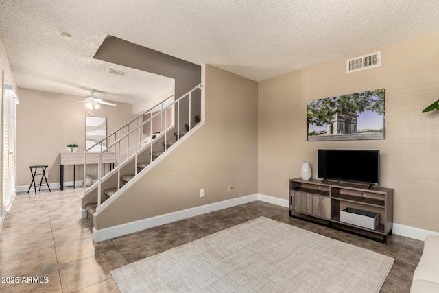 interior space with visible vents, baseboards, a textured ceiling, and ceiling fan