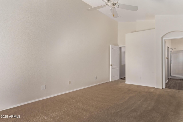 carpeted spare room with ceiling fan and high vaulted ceiling