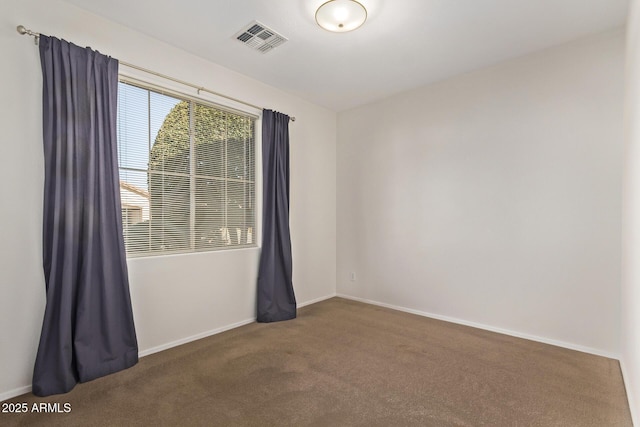 spare room with dark colored carpet