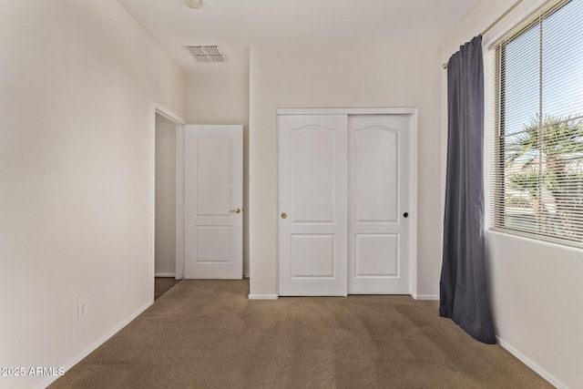 unfurnished bedroom with a closet and carpet flooring