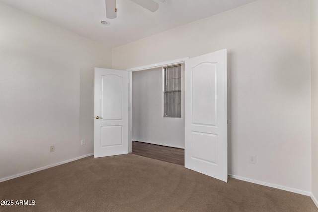 unfurnished bedroom featuring ceiling fan and dark colored carpet