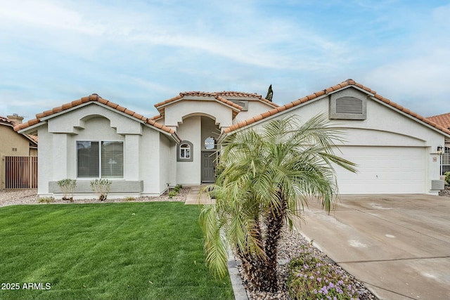 mediterranean / spanish house featuring driveway, an attached garage, fence, a front yard, and stucco siding