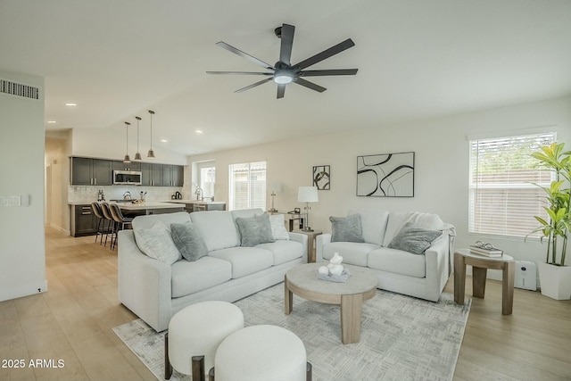 living area with lofted ceiling, ceiling fan, recessed lighting, visible vents, and light wood-type flooring