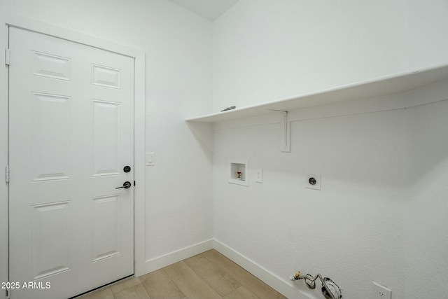 clothes washing area featuring laundry area, baseboards, hookup for a gas dryer, light wood-style floors, and washer hookup