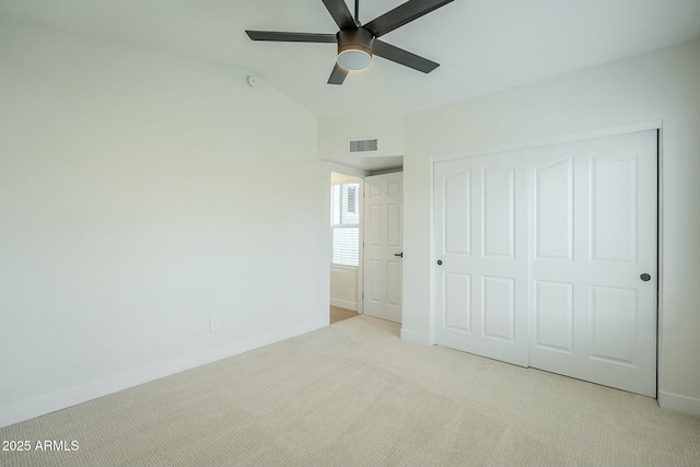 unfurnished bedroom with visible vents, baseboards, lofted ceiling, carpet, and a closet