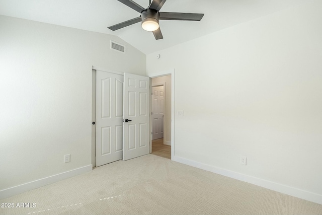 unfurnished bedroom with carpet floors, lofted ceiling, visible vents, and baseboards