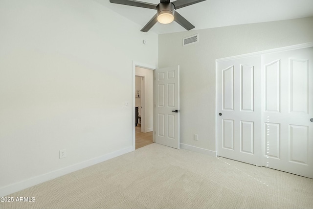 unfurnished bedroom featuring carpet, lofted ceiling, visible vents, a ceiling fan, and baseboards