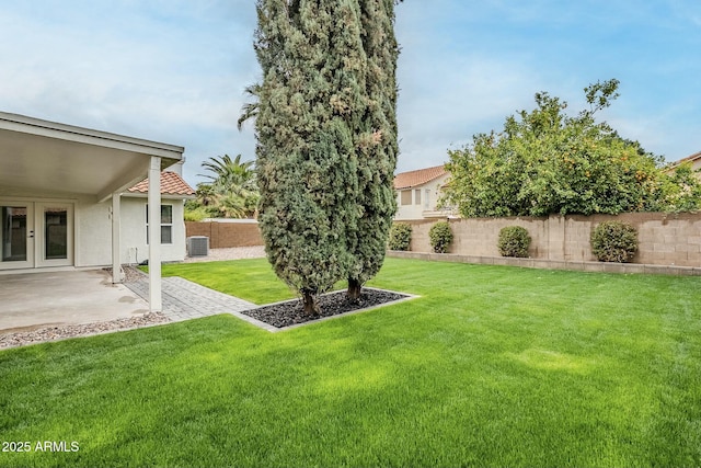 view of yard featuring a fenced backyard, central AC, french doors, and a patio