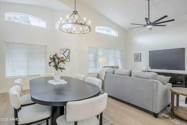 dining room with light wood-type flooring, baseboards, high vaulted ceiling, and a ceiling fan