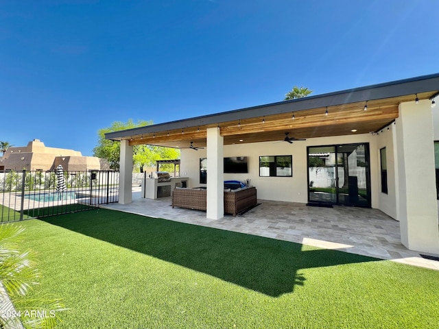 rear view of house featuring a patio area, ceiling fan, a yard, and an outdoor hangout area