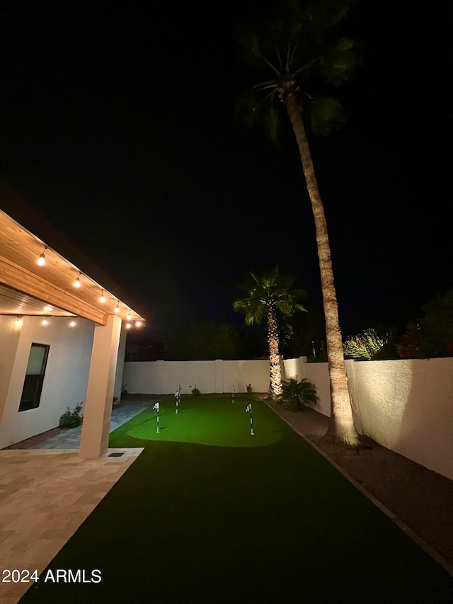 yard at night featuring a patio