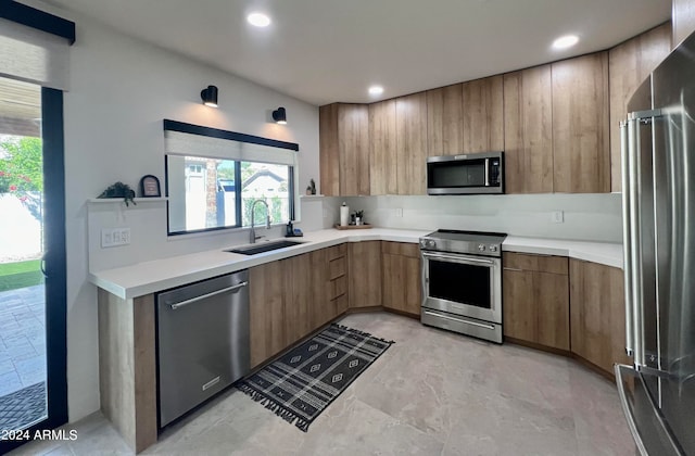 kitchen with appliances with stainless steel finishes, light tile floors, and sink