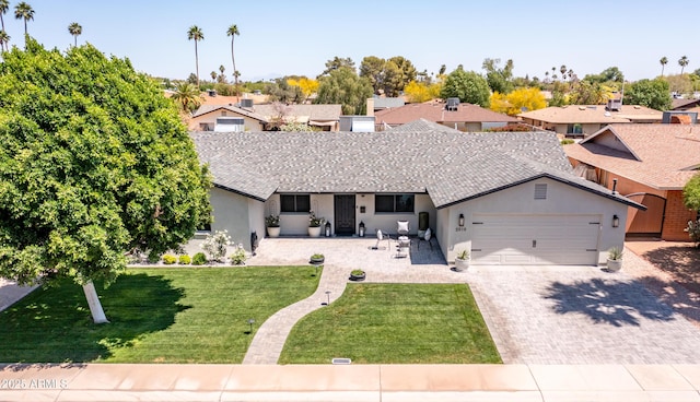 single story home featuring an attached garage, a residential view, stucco siding, a front yard, and driveway