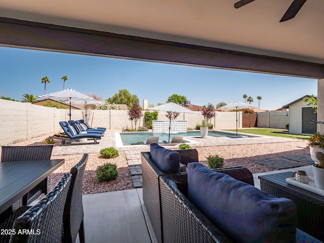 view of patio with a storage shed, outdoor lounge area, an outdoor structure, and a fenced backyard