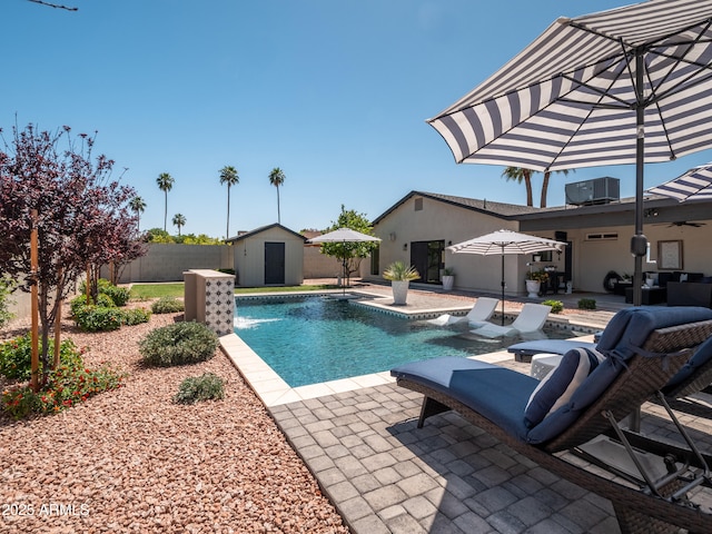 view of swimming pool featuring a patio, cooling unit, an outdoor structure, a fenced backyard, and a shed