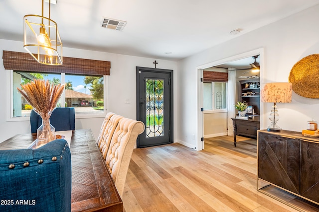 dining space featuring baseboards, light wood-style flooring, and visible vents