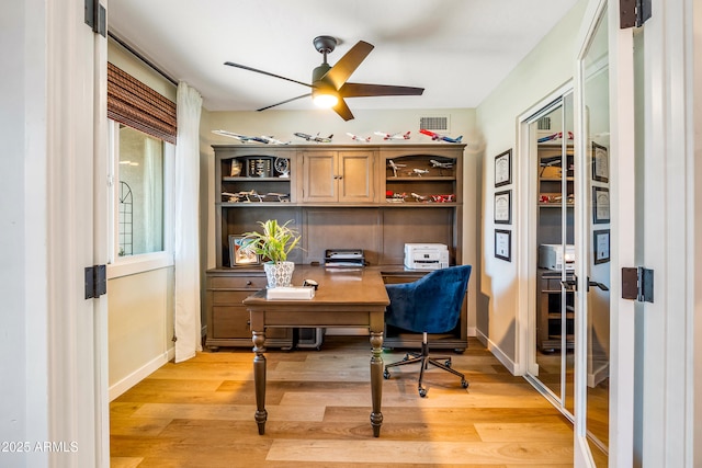 office area with light wood-type flooring, ceiling fan, baseboards, and visible vents