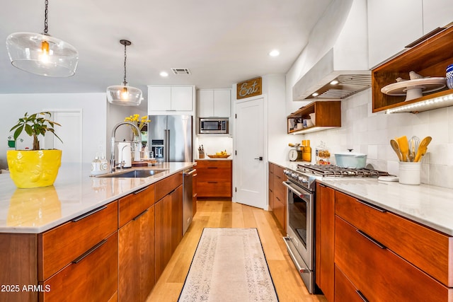 kitchen featuring a sink, high end appliances, open shelves, modern cabinets, and light wood-style floors