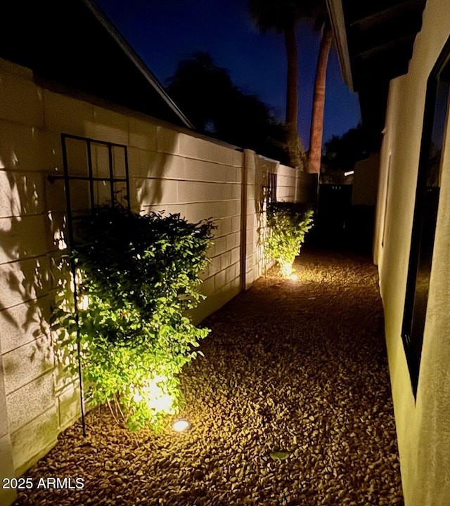 property exterior at night featuring fence