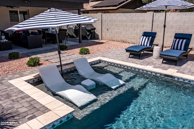 outdoor pool featuring a fenced backyard, a patio, and outdoor dining area