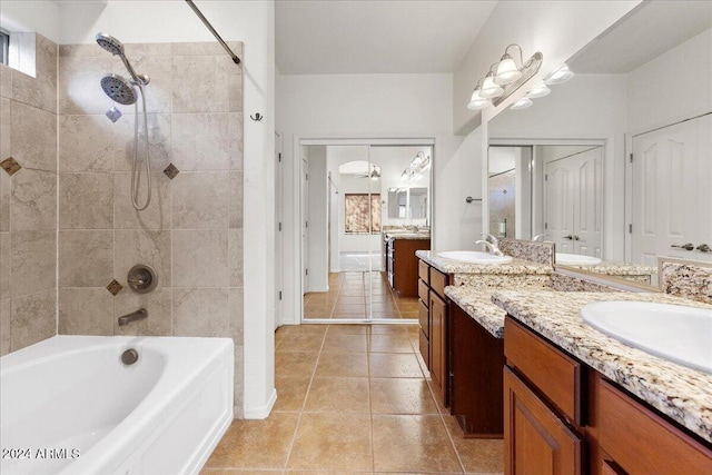 bathroom featuring tile patterned flooring, vanity, and tiled shower / bath combo