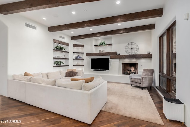 living room with beam ceiling, built in shelves, and dark wood-type flooring