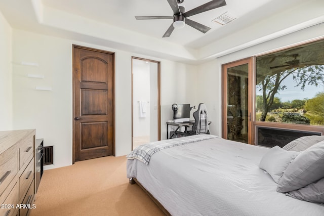 carpeted bedroom with a tray ceiling and ceiling fan