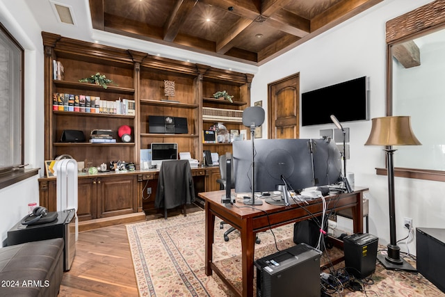 home office with coffered ceiling, beam ceiling, and light hardwood / wood-style flooring