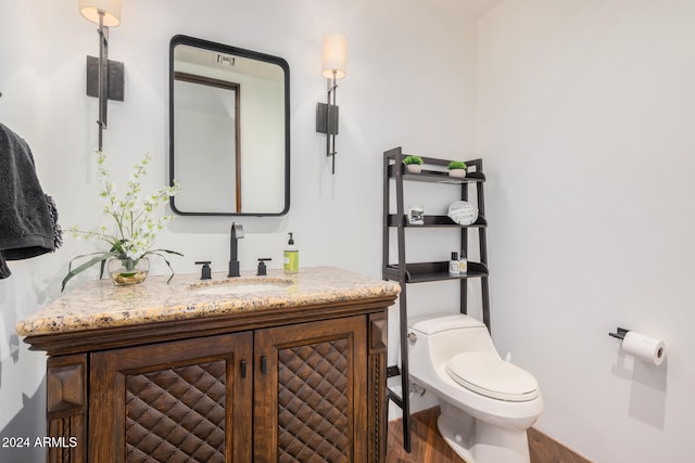 bathroom featuring wood-type flooring, vanity, and toilet