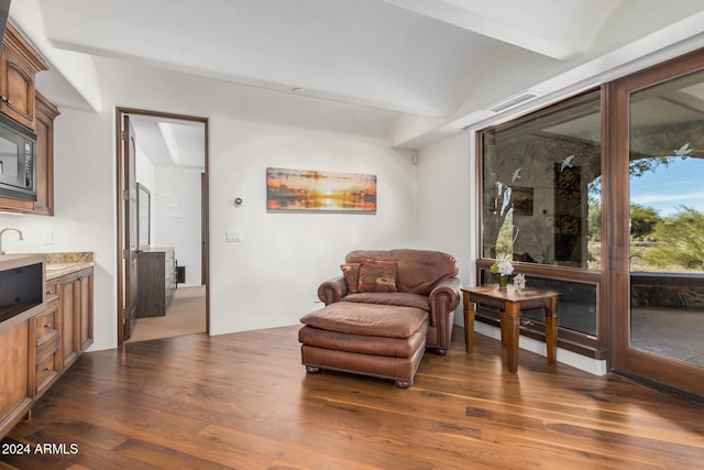 sitting room with dark hardwood / wood-style flooring and lofted ceiling with beams