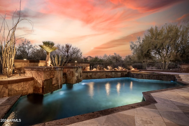 pool at dusk featuring a patio