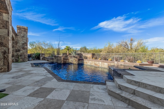 view of pool featuring pool water feature and a patio